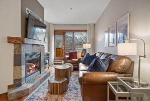 a living room with a couch and a fireplace at RidgeView Loft - Top Floor 2 Bed 2 Bath, Amazing Views in Canmore