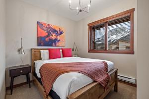 a bedroom with a large bed with red pillows at RidgeView Loft - Top Floor 2 Bed 2 Bath, Amazing Views in Canmore
