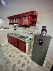 a kitchen with wooden cabinets and a stove top oven at Acogedor apartamento amoblado con parqueadero in Valledupar