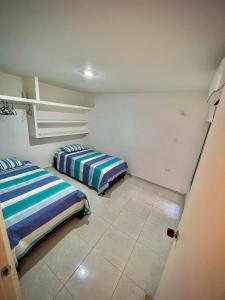 een kamer met 2 bedden in een kamer bij Acogedor apartamento amoblado con parqueadero in Valledupar