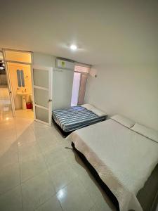 バジェドゥパルにあるAcogedor apartamento amoblado con parqueaderoのベッドルーム1室(ベッド2台付)、バスルームへのドアが備わります。