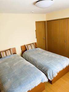 a bedroom with two beds and a cabinet at Okhotsk House Shari in Shari +134 photos
