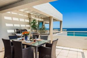 una mesa y sillas en un patio con vistas al océano en Beach View Apartment in Cottesloe, en Perth