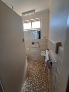 a bathroom with a toilet and a window and a door at Great Western Motel in Great Western