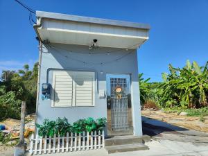 une petite maison bleue avec une porte et une clôture dans l'établissement 寮寓x綺澄 包棟宅, à Île Lamay