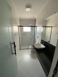 a bathroom with a toilet and a sink and a shower at Recanto da lele in Aparecida +21 photos