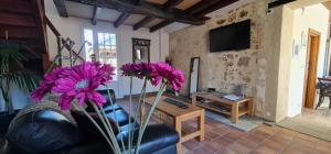uma sala de estar com flores roxas num sofá em Dom Peyreton Prestige cottages set in a charming wine property em Villegouge