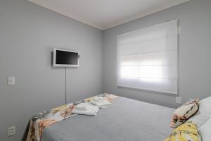 a bedroom with a bed with a tv on the wall at Family Apartment - GRU in Guarulhos