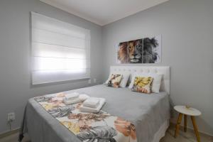 een witte slaapkamer met een groot bed en een deken bij Family Apartment - GRU 307 in Guarulhos