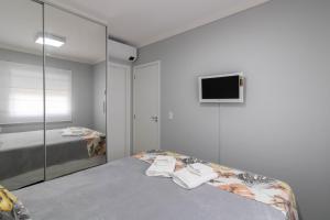 a bedroom with a bed and a tv on the wall at Family Apartment - GRU in Guarulhos