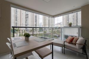 グアルーリョスにあるFamily Apartment - GRU 307のテーブルと椅子のあるバルコニー付きの部屋