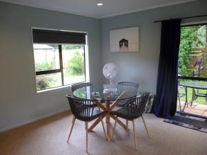 comedor con mesa de cristal y sillas en Picton Country Hideaway, en Picton