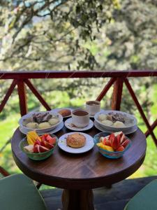 a table with plates of food and fruit on it at Rincón Entre Piedras-Cabaña Entre Montañas in Choachí