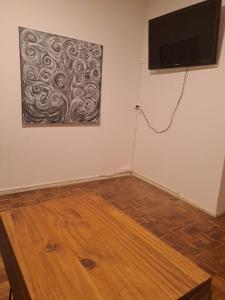 a room with a flat screen tv and a wooden floor at Obelisco in Buenos Aires