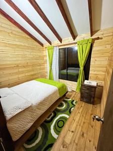 a bedroom with a bed in a wooden room at Rincón Entre Piedras-Cabaña Entre Montañas in Choachí