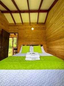 a bedroom with a bed in a wooden room at Rincón Entre Piedras-Cabaña Entre Montañas in Choachí
