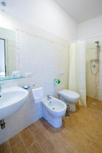 a white bathroom with a sink and a toilet at Hotel Maremma Sul Mare in Montalto di Castro