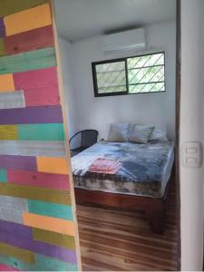 Habitación con cama y pared colorida. en Ojochal studio design conteneur & jardin, en Ojochal