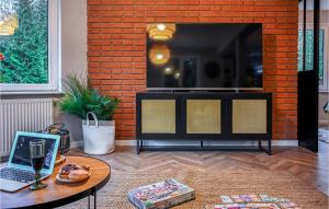 a living room with a tv and a table with a laptop at Lovely Apartment In Stezyca With Sauna in Stężyca