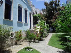 a blue house with potted plants in a yard at Pousada Barroco na Bahia in Salvador