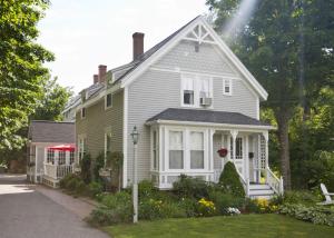 a white house with a porch and a yard at James Place Inn Bed and Breakfast in Freeport