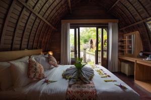 a bedroom with a bed in a room with a window at Klumpu Hill Villas Nusa Penida in Klungkung
