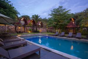 a swimming pool with chaise lounge chairs in front of a house at Klumpu Hill Villas Nusa Penida in Nusa Penida +37 photos