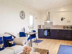 a living room and kitchen with a couch and a table at Lime Tree Lodge in Castle Douglas