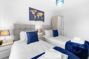 duas camas num quarto com azul e branco em Modern 4 Bedroom House With Parking in Farnham Royal, Slough By Ferndale em Slough