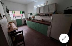 a kitchen with green and white cabinets and a refrigerator at Casa Agni in Treinta y Tres