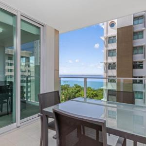 a dining room with a table and a view of the ocean at H on Mitchell Apartment Hotel in Darwin