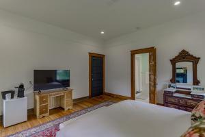 a bedroom with a bed and a flat screen tv at Oak Hall in Vicksburg