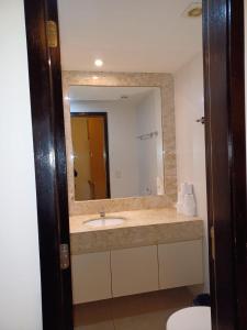 a bathroom with a sink and a mirror at Lindo Flat em resort silencioso e aconchegante in Brasília