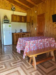 cocina con cama, mesa y nevera en Los Pioneros en Puerto Iguazú