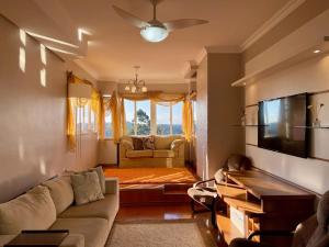 salon z kanapą i telewizorem w obiekcie Bela Vista Gramado w mieście Gramado