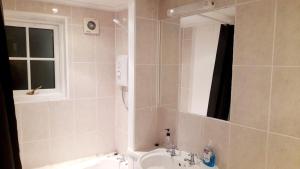 a bathroom with a sink and a mirror at Penzance Cottage in Penzance +8 photos
