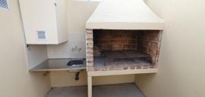 a kitchen with a brick oven and a sink at cabañas arroyo de las piedras in El Calafate