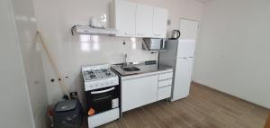 a small kitchen with a stove and a refrigerator at arroyo de las piedras in El Calafate