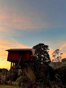 a tree house on a rock with a sunset in the background at Rincón Entre Piedras in Choachí