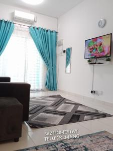 a living room with a tv and blue curtains at Srz Homestay Teluk Kemang PD in Port Dickson
