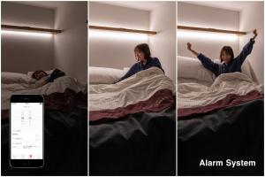 Une femme qui se couche au lit avec ses bras dans l'air dans l'établissement The Millennials Shibuya, à Tokyo