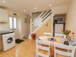 a kitchen and dining room with a table and a washing machine at Courtyard Cottage in Chittlehampton