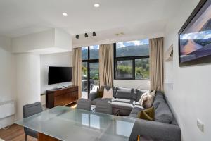 a living room with a couch and a glass table at Lantern 3 Bedroom Terrace with majestic mountain view in Thredbo