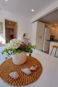 a vase with flowers in it on a table at family friendly 3BR flat - 3min walk to the beach - self contained in Auckland