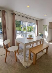 a dining room with a table and two chairs at family friendly 3BR flat - 3min walk to the beach - self contained in Auckland