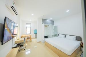 Chanh Huy Apartments & Hotel في مدينة هوشي منه: غرفة نوم بسرير وتلفزيون ومكتب