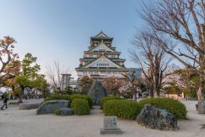 un grande edificio con una torre in un parco di 合綠の宿 203 ad Osaka