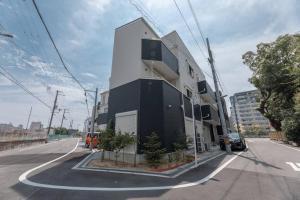 Un edificio bianco e nero sul lato di una strada di 合綠の宿 203 ad Osaka