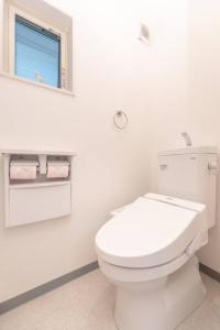 bagno bianco con servizi igienici e finestra di 合綠の宿 203 ad Osaka Altre 8 foto