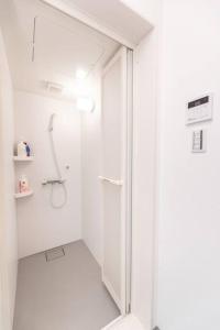 un bagno bianco con doccia e porta in vetro di 合綠の宿 203 ad Osaka